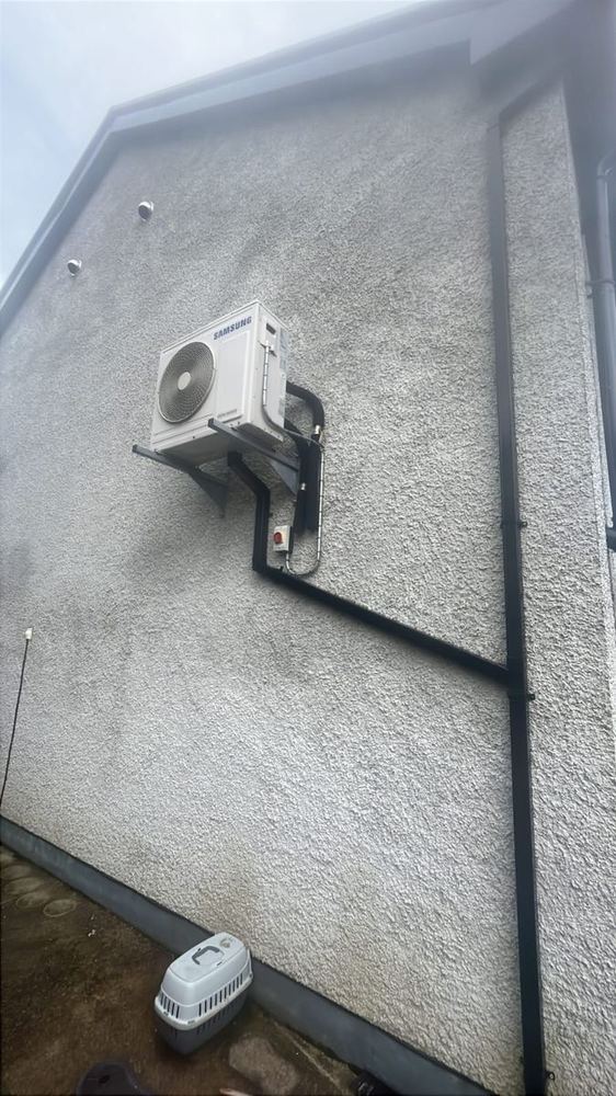 Wall-mounted heat pump unit with pipework